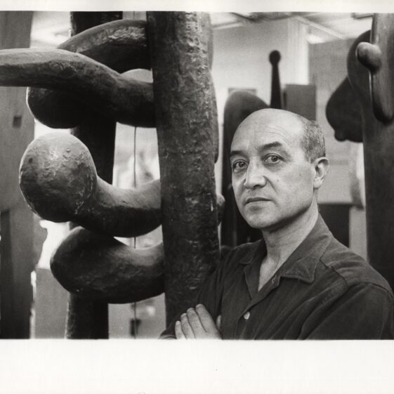 Portrait of artist and designer Isamu Noguchi standing next to one of his sculptures, The Isamu Noguchi Foundation and Garden Museum, New York